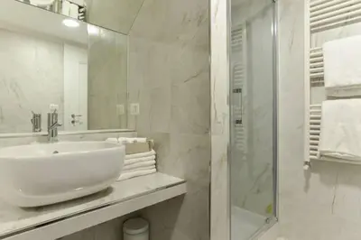 a white bathroom with a sink and a shower at Navona Rubens Lodge in Rome