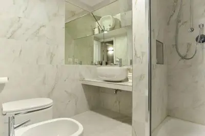 a bathroom with a sink and a toilet and a mirror at Navona Rubens Lodge in Rome