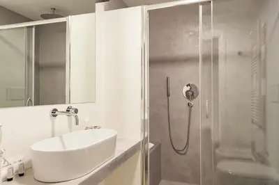 a white bathroom with a sink and a shower at Trevi Art Suite in Rome