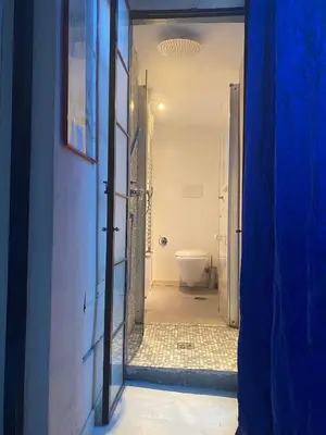 a bathroom with a toilet and a door to a hallway at Trevi Art Suite in Rome