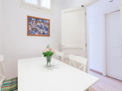 a white table with a vase of flowers on it at Sabelli Nightlife Apartment-LA SAPIENZA-TERMINI STATION in Rome