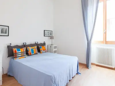 a white bedroom with a bed with colorful pillows at Sabelli Nightlife Apartment-LA SAPIENZA-TERMINI STATION in Rome