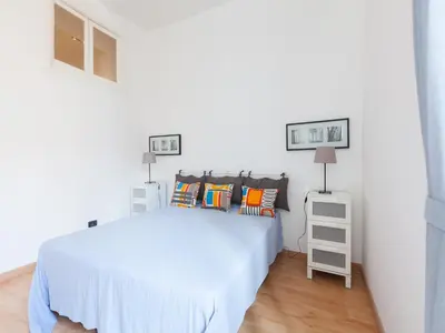 a white bedroom with a white bed with pillows at Sabelli Nightlife Apartment-LA SAPIENZA-TERMINI STATION in Rome