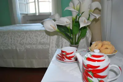 a table with red and white cups and a vase with white flowers at San Peter's Corner in Rome