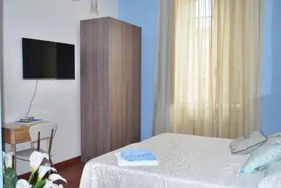 a bedroom with a bed and a desk and a television at San Peter's Corner in Rome