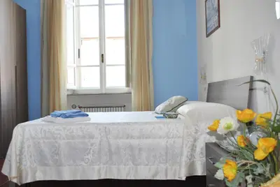 a bed in a room with a window and flowers at San Peter's Corner in Rome