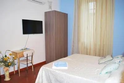 a bedroom with a bed and a table and a tv at San Peter's Corner in Rome