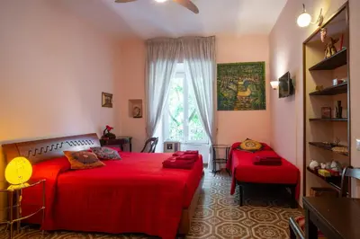 a bedroom with a red bed and a window at Il Leoncino in Rome