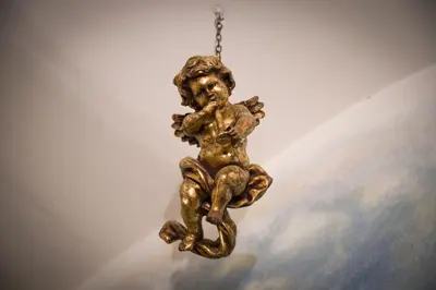 a bronze statue of a boy hanging from a chain at Il Leoncino in Rome