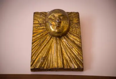 a gold picture of a face on a wall at Il Leoncino in Rome