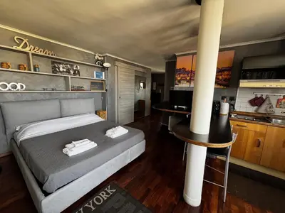 a bedroom with a large bed and a kitchen at Casetta Fleming in Rome