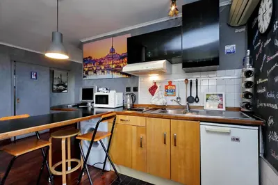 a kitchen with a sink and a counter with stools at Casetta Fleming in Rome