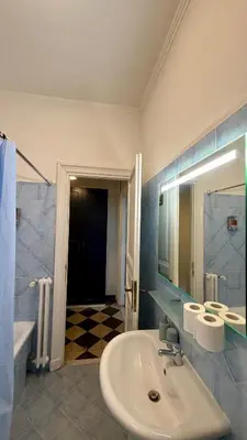 a bathroom with a sink and a mirror and a tub at St. John Apartment in Rome