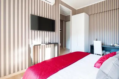 a bedroom with a bed with a red blanket and a flat screen tv at Happy Holiday in Rome b&b in Rome