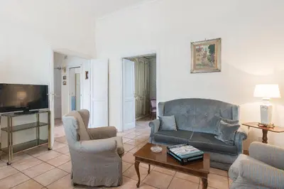 a living room with a couch and chairs and a tv at Domus al Palatino in Rome