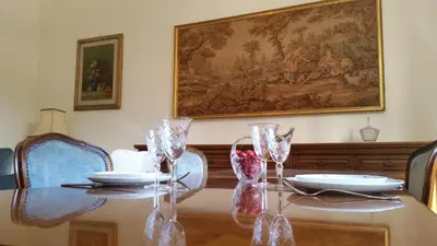 a dining room table with glasses and a painting on the wall at Domus al Palatino in Rome