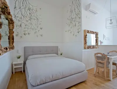 a white bedroom with a bed and a table at Primo Piano Suites in Rome