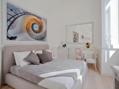 a bedroom with a bed with a painting on the wall at Primo Piano Suites in Rome