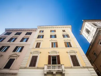 a tall yellow building with a balcony on it at Primo Piano Suites in Rome