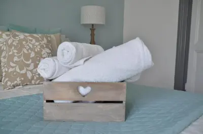 a bed with towels and a wooden box with a heart on it at TuttoTondo Roma in Rome