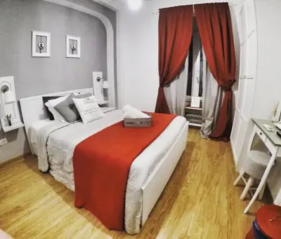 a bedroom with a bed with a red blanket at TuttoTondo Roma in Rome