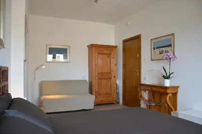 a bedroom with a couch and a chair and a door at Studio Cardello Colosseum in Rome