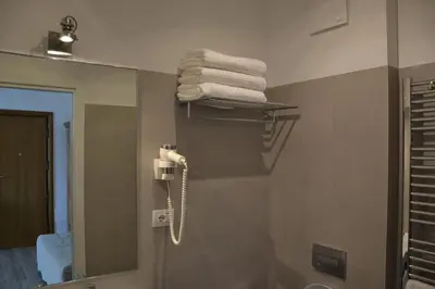 a bathroom with a towel rack and a mirror at Studio Cardello Colosseum in Rome