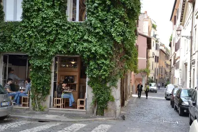 a ivy covered building on a street with people sitting outside at Studio Cardello Colosseum in Rome