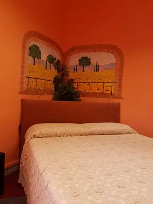 a bedroom with a bed with an orange wall at Le Tre Sorelle B&b Garbatella in Rome