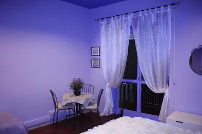 a bedroom with a table and a window with curtains at Le Tre Sorelle B&b Garbatella in Rome
