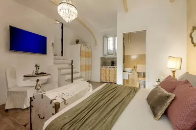 a bedroom with a large bed and a tv on the wall at St.Peter's Mirror - Romantic View in Rome