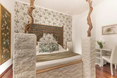 a bedroom with a large bed with a wooden headboard at St.Peter's Mirror - Romantic View in Rome