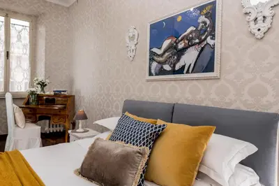 a bedroom with a bed with yellow and white pillows at St.Peter's Mirror - Romantic View in Rome