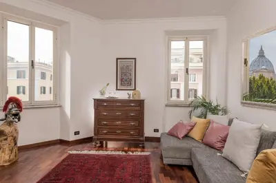 a living room with a couch and two windows at St.Peter's Mirror - Romantic View in Rome