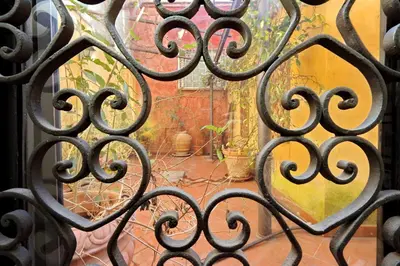an iron gate with a view of a courtyard at Appartamento Sforza a Monti in Rome