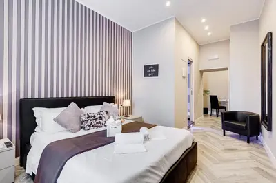 a bedroom with a large bed and a chair at Hanky Suite in Rome