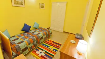 a small room with a bed and a table with a lamp at Rental in Rome Sardegna Apartment in Rome