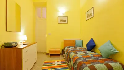 a yellow room with a bed and a dresser and a bedroom at Rental in Rome Sardegna Apartment in Rome