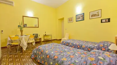 a hotel room with a bed and a table and a mirror at Rental in Rome Sardegna Apartment in Rome