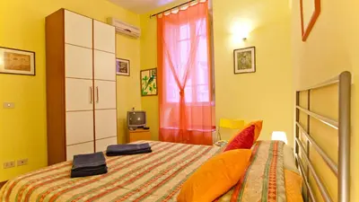 a small bedroom with a bed and a window at Rental in Rome Sardegna Apartment in Rome
