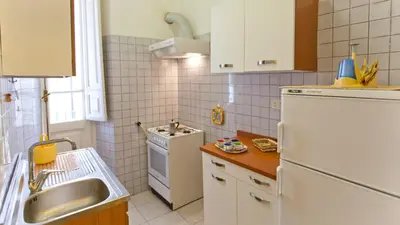 a kitchen with a white refrigerator and a sink at Rental in Rome Sardegna Apartment in Rome