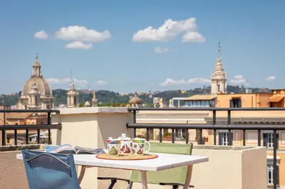 a table and chairs on top of a balcony at Argentina Penthouse by Rental in Rome in Rome