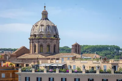 a building with a clock tower in the background at Argentina Penthouse by Rental in Rome in Rome