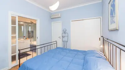a bedroom with a blue bed and a bathroom at Rental in Rome Risorgimento view Aparment in Rome