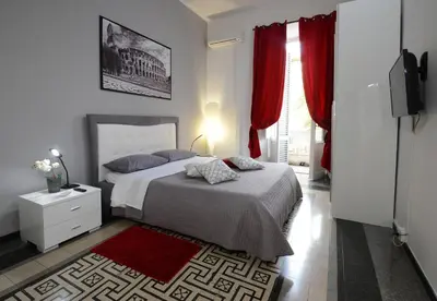a bedroom with a large bed with red curtains at Casa Dania in Rome