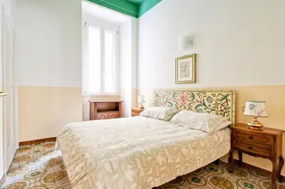 a bedroom with a bed and a table and a window at Roman Apartment in Rome