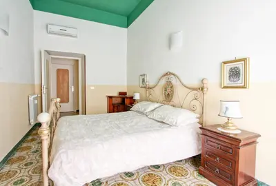 a bedroom with a bed and a dresser with a lamp at Roman Apartment in Rome