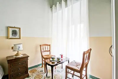 a room with a table and two chairs and a window at Roman Apartment in Rome
