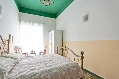 a bedroom with a bed with a green ceiling at Roman Apartment in Rome