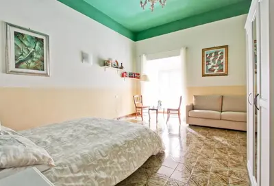 a bedroom with a bed and a couch and a table at Roman Apartment in Rome